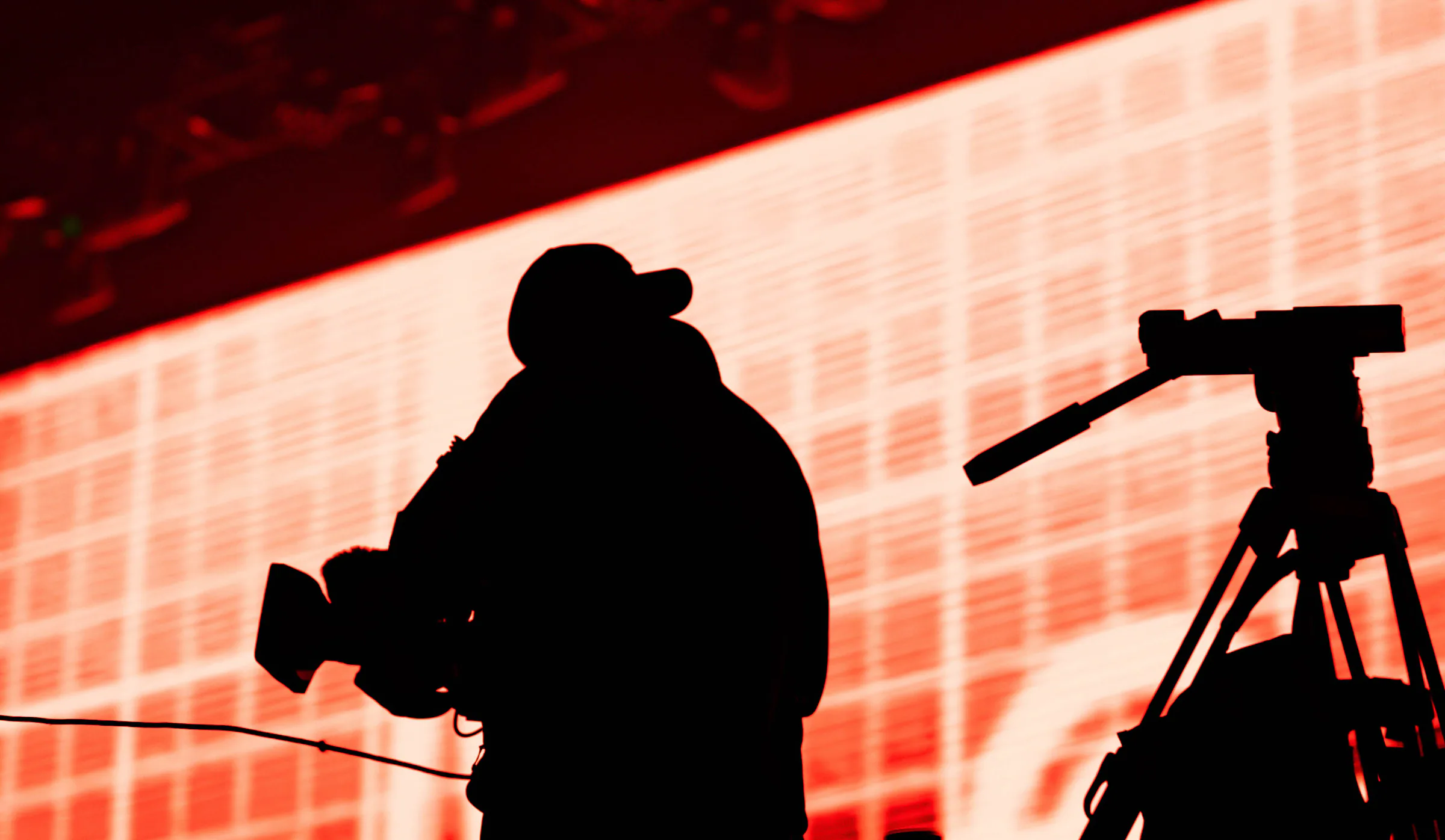 The silhouette of a camera operator filming during a live production